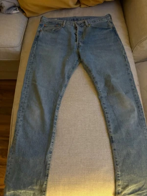 Levi's 501 ljusblå straight jeans - Klassiska vintage Levi's 501 jeans i ljusblå tvätt med rak passform och normal midja. Jeansen har fem fickor, knappgylf och är tillverkade i slitstark bomullsdenim. W 32 L 30. Skicka bud:)