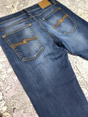 Nudie Jeans - Ett par riktigt schyssta och sköna Nudie Jeans. I storlek 31/34 och bra kvalité i modelled Long Tight John. I skick 9/10. Hör av dig vid frågor kring varan‼️🤩