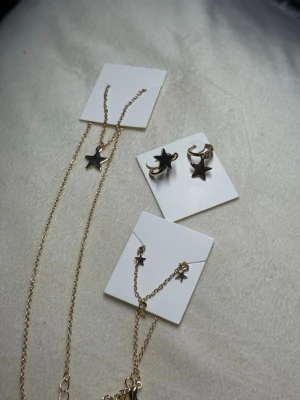 Guldigt Stjärnset – Halsband, Armband & Örhängen - Fint smyckeset i guldton med små stjärndetaljer. Innehåller halsband, armband och örhängen – allt helt nytt. Perfekt som julklapp eller present.  💰 Nypris: ca 149–199 kr per del (värde ca 450–550 kr totalt). 