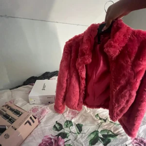 Rosa pälsjacka med krage - Säljer en fluffig och trendig rosa pälsjacka med klassisk krage. Jackan är kortare i modellen och har en riktigt mjuk och gosig känsla. Perfekt för dig som vill sticka ut och addera färg till din outfit.
