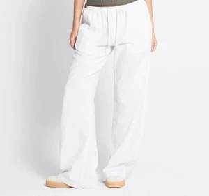 Vita linnebyxor med snörning, strl L - Säljer ett par fräscha vita linnebyxor i storlek L. Byxorna har bred resår i midjan och snörning för extra komfort. Modellen är loose och har en skön wide passform med raka ben. Perfekta för varma dagar och chill stil. Aldrig använda 