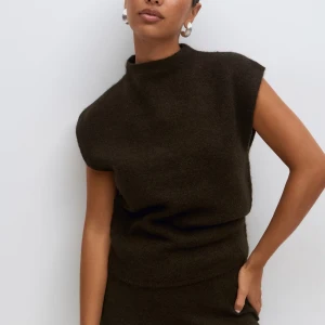 Mörkbrun stickad ärmlös topp -  Säljer en mörkbrun stickad topp med hög hals ärmlös design.💕💕Helt oanvänd, då den är för stor tyvärr