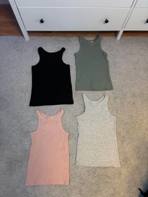 Fyra ribbade linnetoppar KappAhl - Säljer ett paket med fyra ribbade linnetoppar från KappAhl i storlek 170, passar mig som är XS-S. Färgerna är svart, ljusrosa, grön och ljusgrå. Alla topparna har rundad hals och är ärmlösa med slim passform. Perfekt att matcha med jeans eller shorts för en chill look.💕💕