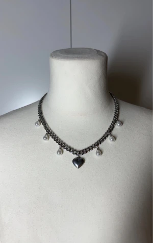 Halsband med pärlor och hjärta - Handgjort kedjehalsband med pärlor. Kedjan är 7mm bred och 45cm lång. Allt i rostfritt stål förutom pärlorna. Fast pris satt efter materialkostnader och tillverkning. Köp gärna via köp nu, snabb leverans.    