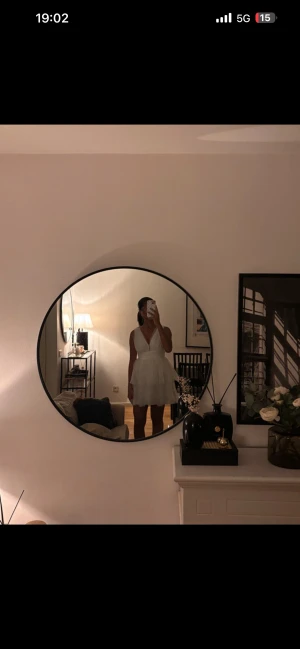 Vit kort klänning från Gina Tricot - Supersöt vit klänning från Gina Tricot med v-ringad omlott upptill och volang i kjolen. Klänningen är ärmlös och har ett lager av tunn, luftig polyester som ger en fluffig känsla. Perfekt för sommarens alla tillfällen när du vill känna dig extra fin.