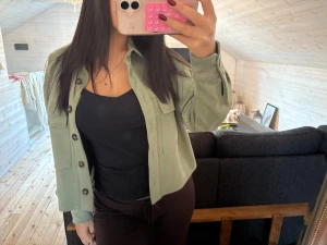 Jacka -  En tunn grön jacka med knappar!