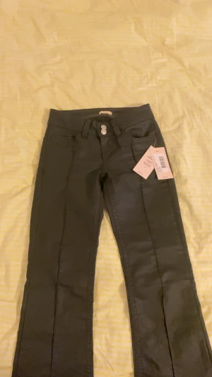 Coated low waist stitch jeans  - Hej jag säljer dessa oanvända byxor från Nelly eftersom de tyvärr är för småa :( De är i storlek 32 och endast testade. Ordinarie pris på hemsidan är 699kr. Skriv gärna för frågor och innan köp 🥰