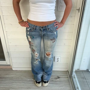 Bootcut jeans med slitningar - Ljusblå jeans med slitningar och mönstrar i storlek S-XS