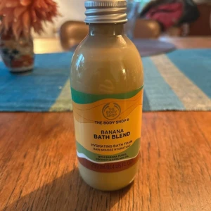 Banana Bath Blend från The Body Shop - Banana Bath Blend är ett återfuktande badskum med bananpuré, kokos- och avokadoolja, innehåller 250 ml. Perfekt för dig som älskar fruktiga dofter och mjuk hud.