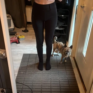 Svarta tighta högmidjade ridbyxor - Säljer ett par svarta, tighta ridbyxor med hög midja och raka ben. De har fickor bak och är gjorda i ett stretchigt material som sitter snyggt och bekvämt. Jag brukar vika ner dem så de blir lågmidjade och de håller sig nere. 