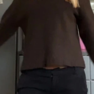 Brun stickad tröja  - Mysig brun stickad tröja med lång ärm och avslappnad, lite croppad passform. Tröjan har ribbade muddar vid ärmslut och nederkant, perfekt för lager på lager under kyliga dagar.