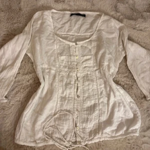En vintage blus från Zara - En trendig vit vintage blus från Zara, i mycket bra skick med fina detaljer och knappar i mitten. Storlek L men passar även S och M.