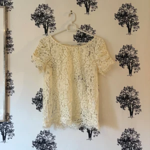 Vit spetsblus från Stockh LM - Säljer en superfin vit blus från Stockh LM i storlek 34. Blusen är helt i spets med blommigt mönster, korta ärmar och rund halsringning. Den har en liten knapp i nacken och snygga spetsdetaljer vid ärmslut och nederkant. Perfekt för dig som gillar romantisk stil!