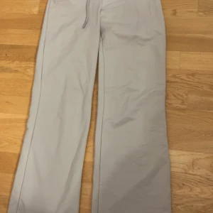 Beige mjukisbyxor från Lager157 - Snygga beige mjukisbyxor från Lager157, modell Ebba. Byxorna har rak passform med snörning i midjan för extra komfort. Tillverkade i mjukt bomullsmaterial som känns skönt mot huden. Perfekta för chill dagar eller när du vill vara extra bekväm. Klippt av lappen men har storlek xxs/xs så den är det