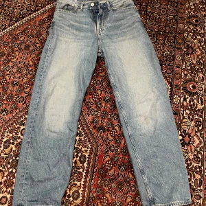 Loose fit jeans från H&M ljusblå - Säljer ett par ljusblå jeans från H&M i loose fit-modell. De har klassisk femficksdesign, raka ben och är tillverkade i jeansmaterial. Perfekta för dig som gillar avslappnad stil och vill ha bekväma jeans med lite extra utrymme.