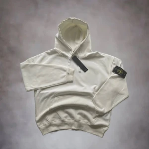 Stone island hoodie - Stone Island Tröja - Vit, Storlek M - Helt Ny med Prislapp!  Beskrivning:  Säljer en helt ny och oanvänd Stone Island tröja i storlek M. Tröjan är i färgen vit och är i perfekt skick, fortfarande med original prislapp kvar. En klassisk och stilren tröja från ett av de mest eftertraktade märkena. Perfekt för den som vill uppdatera sin garderob med en tidlös kvalitetsplagg.  *   Märke: Stone Island *   Storlek: M *   Färg: Vit *   Skick: Nytt med prislapp  Passa på att fynda en Stone Island tröja 