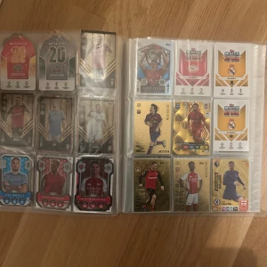 Match Attax Fotbollskortsamling - En grym samling Match Attax fotbollskort med stjärnor som Messi, Ronaldo och Saliba. Perfekt för dig som älskar fotboll, samlar på kort eller vill ha något unikt att visa upp för kompisarna. Flera specialkort och glittriga Squadzone-kort ingår. Samla, byt och spela!