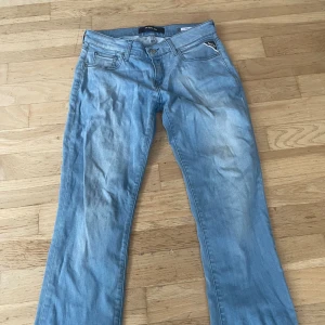 Replay Vicky ljusblå jeans, bootcut - Säljer ett par Replay Vicky jeans i ljusblå tvätt med klassisk femficksdesign och bootcut-ben. Jeansen har låg midja och är tillverkade i mjukt jeansmaterial med snygga detaljer vid fickorna. Perfekt för dig som gillar avslappnad stil.