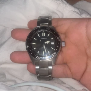 Seiko Prospex svart dykarklocka 40,5mm - Seiko Prospex SPB143J1 – Automatisk dykklocka 40.5 mm Säljer min Seiko Prospex SPB143J1, en riktigt fin automatisk dykklocka (200 m). Klassisk design med svart/grå sunburst-tavla och rostfritt stål. Klockan fungerar helt utan problem – håller tiden bra och känns robust som bara Seiko kan. ✅ Modell: SPB143J1 ✅ Automatiskt urverk (6R35) ✅ 40.5 mm boett ✅ Vattentät till 200 m ✅ Original stållänk (saknar extra länkar) ✅ Inget certifikat eller kvitto – därav priset Klockan är använd men i fint skick,