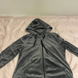 Grå velour hoodie med dragkedja - Mjuk och skön grå hoodie i velour från Gina tricot  Tröjan har huva med snörning, långa ärmar och praktisk dragkedja framtill. Fickor på magen och en chill vibe som passar perfekt till häng eller när du vill vara extra comfy.