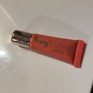 Dewy Blush från makeup mekka - Glossy cheek tint i färgen Papaya. Kommer i en smidig tub innehåller 5 ml. Ger en fräsch, glansig finish med en persikoorange ton. Vegansk, använd ca 2ggr