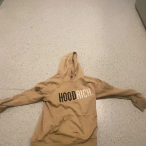 Två Hoodrich hoodies i svart och beige - Säljer två hoodies från Hoodrich, en i beige med stor HOODRICH-logga på bröstet och en svart. Beiga är  s-m svarta är M sitter skönt 