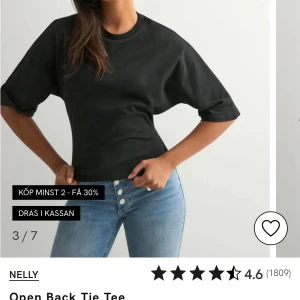 Svart topp med öppen rygg från Nelly - Svart topp från Nelly med rund halsringning och halvlånga ärmar. Baksidan har en öppen rygg med en snygg knytning i midjan som ger en cool och trendig look. Tillverkad i mjuk bomull som känns skön mot huden.