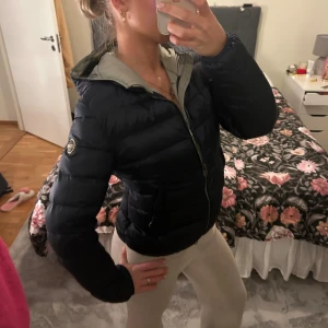 Mörkblå dunjacka från Colmar - Säljer en snygg mörkblå dunjacka från Colmar Originals med huva och dragkedja framtill. Jackan är använd men har tagits hand om bra!! Storlek 42 men motsvarar XS/S