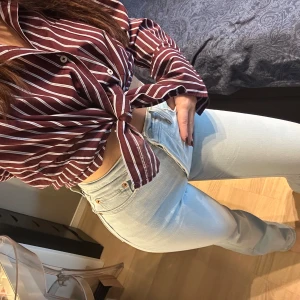 Levi's 501 ljusblå bootcut jeans  - Säljer ett par Levi's 501 jeans i ljusblå tvätt. Modellen är högmidjad och bootcut med fem fickor. Jeansen har Levi's ikoniska läderpatch bak och röd logotagg vid bakfickan. Perfekt för dig som gillar tidlös denimstil. Ny pris 1199kr. W27/L29