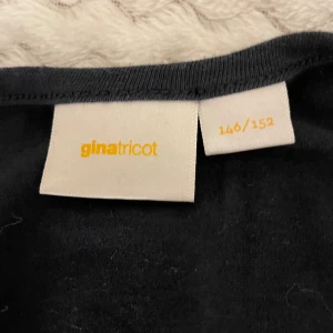 Svart långärmad topp Gina Tricot - Svart långärmad topp från Gina Tricot i storlek 146/152. Basic tröja urringad i bak.