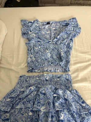 Blåvit mönstrad set från Gina Tricot - Säljer en blåvit set från Gina Tricot med vackert mönster. Toppen är i xl och kjolen är i L. Kan gå ner i pris vid snabb affär☺️☺️