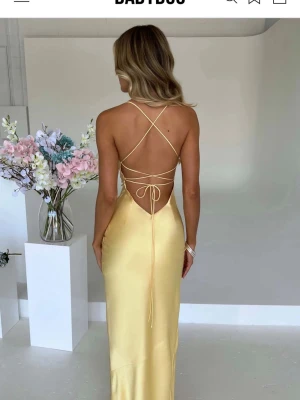 Ljusgul balklänning  - Säljer en ljusgul klänning från Babyboo i storlek M. Klänningen har en hög slits och en öppenrygg som är justerbar! Pris kan förhandlas!