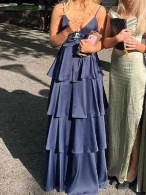 Balklänning  - Säljer min jättefina marinblåa balklänning i satin. Nyskick, använd en gång och kemtvättad. Insydd i kupan men går att sprätta upp. 