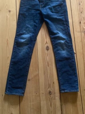 Levi's 511 blå jeans W29 L32 - Säljer ett par klassiska Levi's 511 jeans i mörkblå tvätt. Modellen har en slim passform med raka ben och snygga kontrastsömmar. Tillverkade i slitstarkt jeansmaterial med fem fickor och läderpatch bak i midjan.