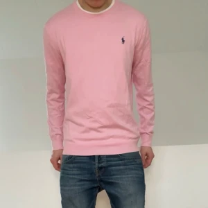 Rosa Ralph Lauren Tröja - Säljer en sjukt fet och populär rosa tröja från Polo Ralph Lauren. Tröjan är i bra skick utan nåra defekter. Den är i strl L men skulle säga den sitter som en M! Hör gärna av er vid frågor eller funderingar!!