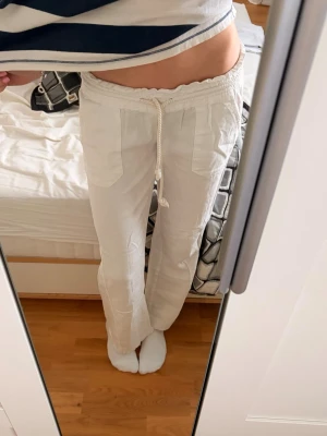 Roxy linnebyxor - Säljer ett par vita linnebyxor med snören, dessa är perfekta till varma sommardagar då man vill ha en chill look💞☀️säljer de eftersom att de vart för korta på mig, jag försökte göra de lite längre och det finns bild på änden av byxan💞innerbenslängd:75cm     Waist:76cm