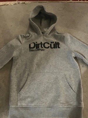 Dirt Cult Hoodie - En grå Dirt cult hoodie, storlek 158-164. Är i bra skick och har inte använts så många gånger.