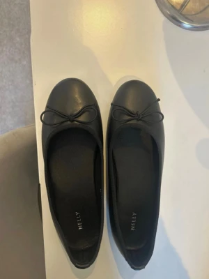 Svarta ballerinaskor från Nelly - Jättefina svarta ballerina skor från Nelly i storlek 38. Köpta i andra hand på Vinted, men var tyvärr för små för mig så testar att sälja vidare. Aldrig använda av mig och enligt förra säljaren ska de varit använda en gång (mycket fint skick). Skriv för fler bilder eller vid frågor!!💕