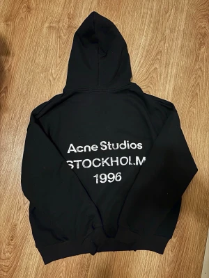 Acne studios hoodie ”Stockholm 1996” - Säljer min äkta Acne Studios “Stockholm 1996” hoodie i svart, storlek S. Hoodien är i toppkondition utan tecken på användning – inga fläckar, hål eller blekning. Tyget håller hög kvalitet, är bekvämt och detta är en av de mest ikoniska modellerna från Acne Studios. Unisex-passform och lätt att styla med allt från jeans till kostymbyxor. Svår att få tag på i detta skick. 