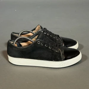 Lanvin Cap Toe  - Klassiska Lanvin Cap Toe i svart med lackad/glansig tå. Storlek 42 (passar även 43). Skorna är använda men fortfarande i bra skick | Defekter: Ej original sula, slitage vid sulan | Medföljer: Inget (endast skorna) | Passform: Normal, något stor i storleken | sulan är målad med vit färg! 