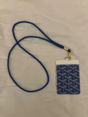 Blå go4yard plånbok med axelrem - Jag säljer en helt ny go4yard plånbok med axelrem i färgen blå med vita detaljer