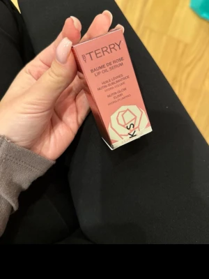 By Terry Baume de Rose Lip Oil Serum - By Terry Baume de Rose Lip Oil Serum i färgen 1. Candy Rose. Kommer i en snygg rosa och silverfärgad förpackning med rosdetalj. Innehåller rosextrakt, multivitaminkomplex och skimrande pigment. Ger volym och glow till läpparna. 4,5 ml.