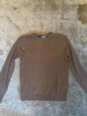 Beige merinoulltröja These Glory Days - Säljer en stilren beige tröja från These Glory Days i mjuk och tunn merinoull. Nypris 800kr, aldrig använd men säljer för 399kr. Tröjan har rund halsringning, lång ärm och en klassisk passform som funkar till allt. Perfekt för lager-på-lager under höst och vinter.