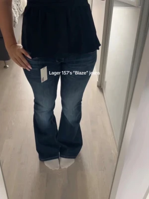 Blå bootcut jeans lager 157 - Säljer ett par blå bootcut jeans med snygg slitning och klassisk femficksmodell. Jeansen har låg midja och är tillverkade i ett mjukt denimtyg som ger en skön passform. Köpte för 400kr