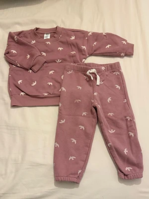 Jätte fin flickkläder 🎀 - Jätte fin  tvådelat barnset med tröja och byxor från Gerber, i dammigt rosa med vitt fågelmönster. Setet är gjort i bomull och polyester och har ribbade muddar samt dragsko i midjan.