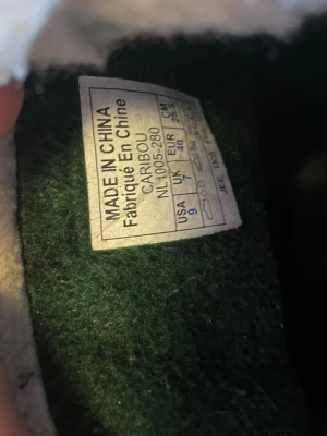 Sorel Caribou vinterboots strl 40 - Säljer ett par klassiska Sorel Caribou boots i brun och svart med varm, vit fleecefoder. Ovandelen är i skinn och nederdelen i gummi, perfekta för kalla vinterdagar. Snörning framtill och rejäl sula för bra grepp. Storlek 40 (EU).