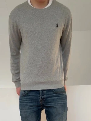 Grå Ralph Lauren Tröja - Säljer en sjukt fet raffe tröja i färgen grå. Hoodien är i bra skick förutom att lappen är borta fast de är inget som syns eller påverkar själva tröjan, men skulle säga att tröjan sitter som M. Hör gärna av er vid frågor eller funderingar!!