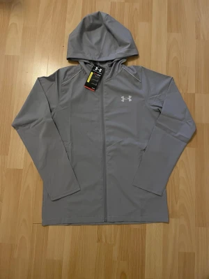 Under Armour Jacka - Grå Under Armour jacka/vindjacka helt ny i storlek M, men passar som S/XS. Den har väl fungerande reflex. Kommer med dustbag och tags. Mått finns. Prisförslag eller frågor är välkomna! 💯💬