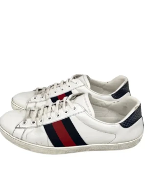 Gucci ace - Snygga vita sneakers från Gucci i läder med klassiska röd och marinblå ränder på sidorna. Skorna har vita snören, låg profil och detaljer i mörkblått vid hälen. Perfekta för dig som gillar stilrena och lyxiga sneakers. 100% äkta vid frågor hör av er! Rensar garderoben! 