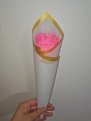 Konstgjorda ros/er i kon med Dior-band - Säljer en konstgjord rosa ros med glitter, inslagen i en vit kon med guldkant. Buketten är dekorerad med ett vitt band med Dior-logga. Perfekt som present eller dekoration. 1st 20 kr, 3st 70 kr, 7st 150 kr, 10 st 200 kr, 12st 240 kr